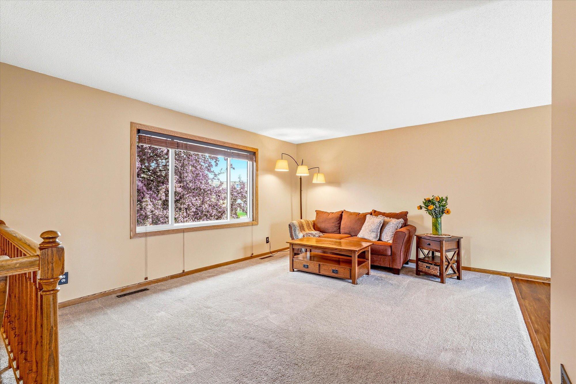 Spacious living room filled with natural light and large front window views overlooking the beautiful flowering crab tree.