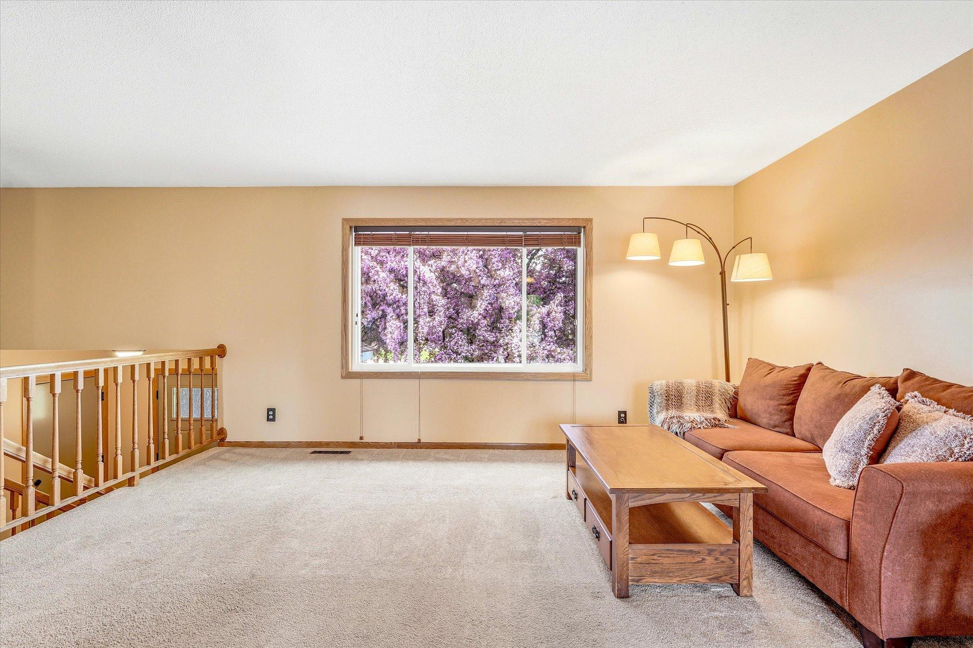 Spacious living room filled with natural light and large front window views overlooking the beautiful flowering crab tree.