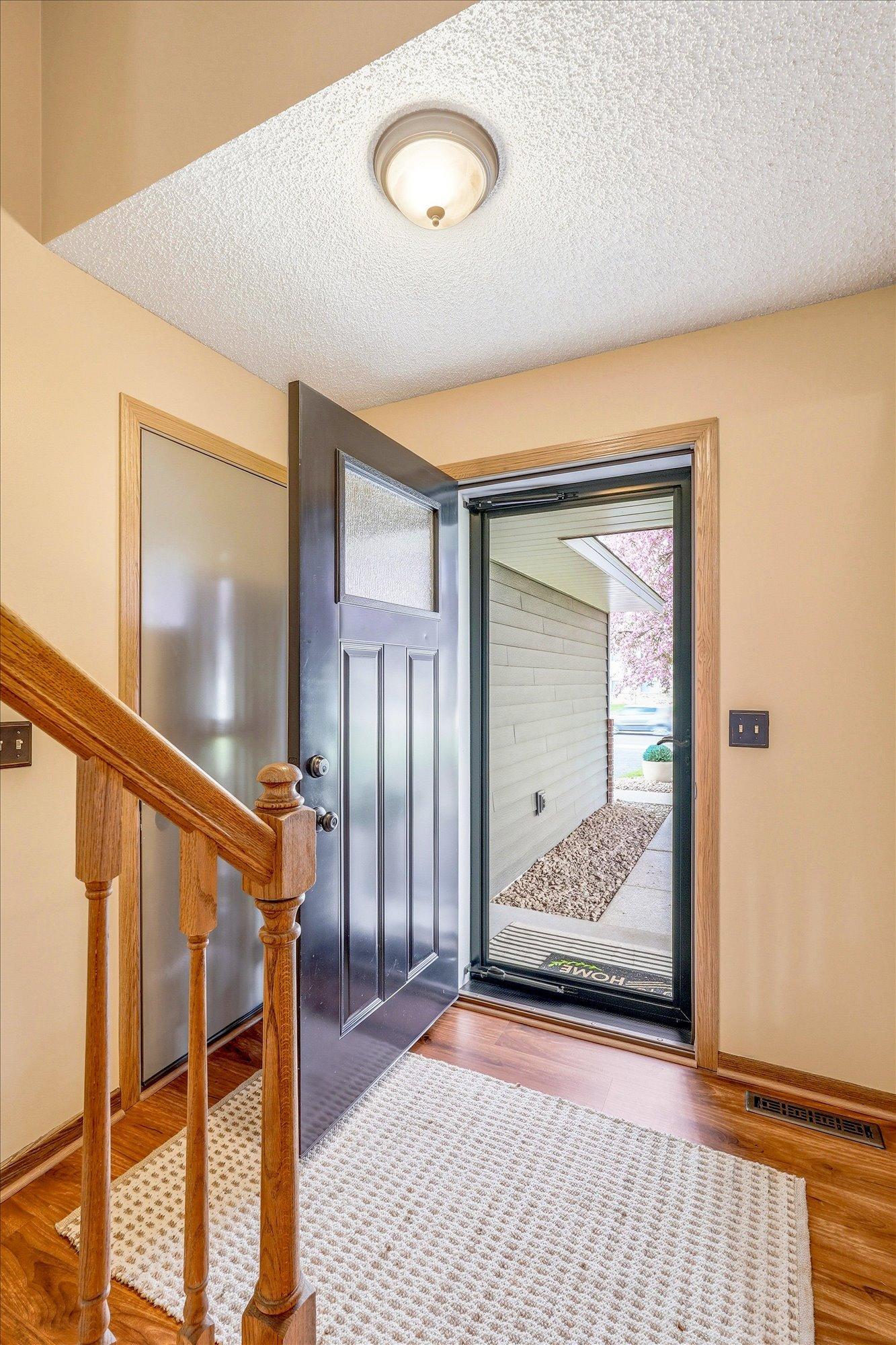 Bright and welcoming foyer with warm woodwork and an open split-level layout.