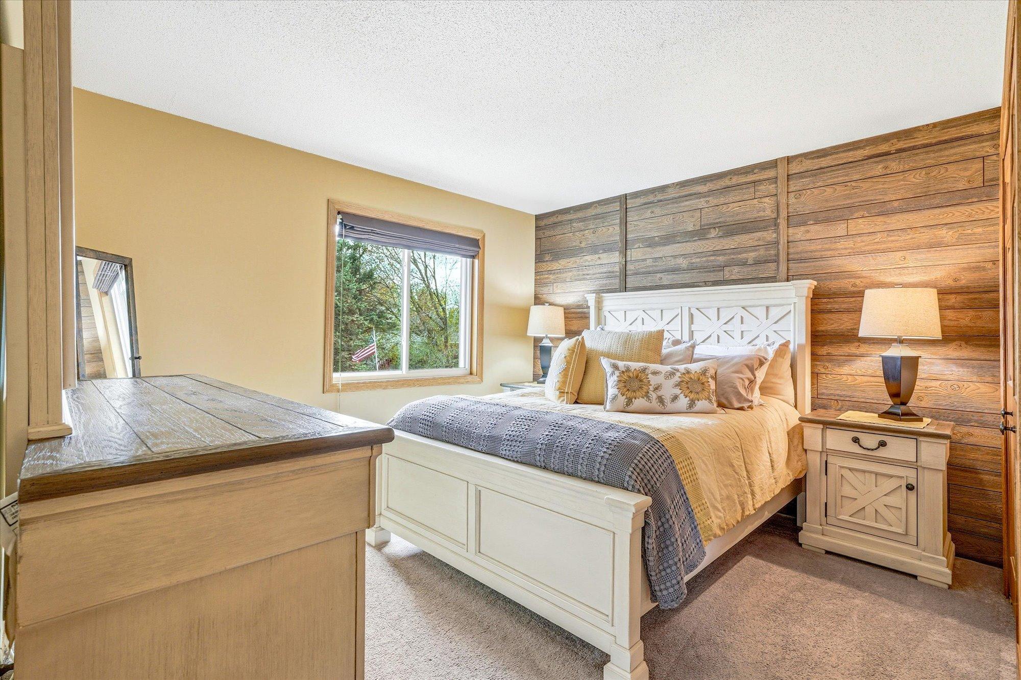 Comfortable primary bedroom featuring warm accent wall details and neutral finishes.