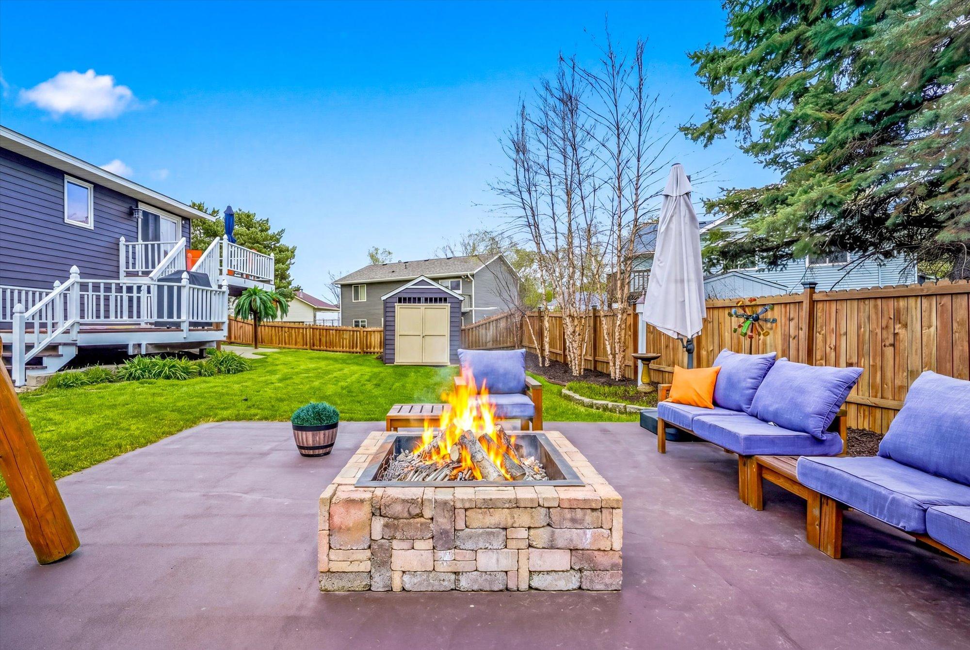 Gather around the inviting backyard firepit patio and enjoy peaceful evenings in the beautifully landscaped yard.