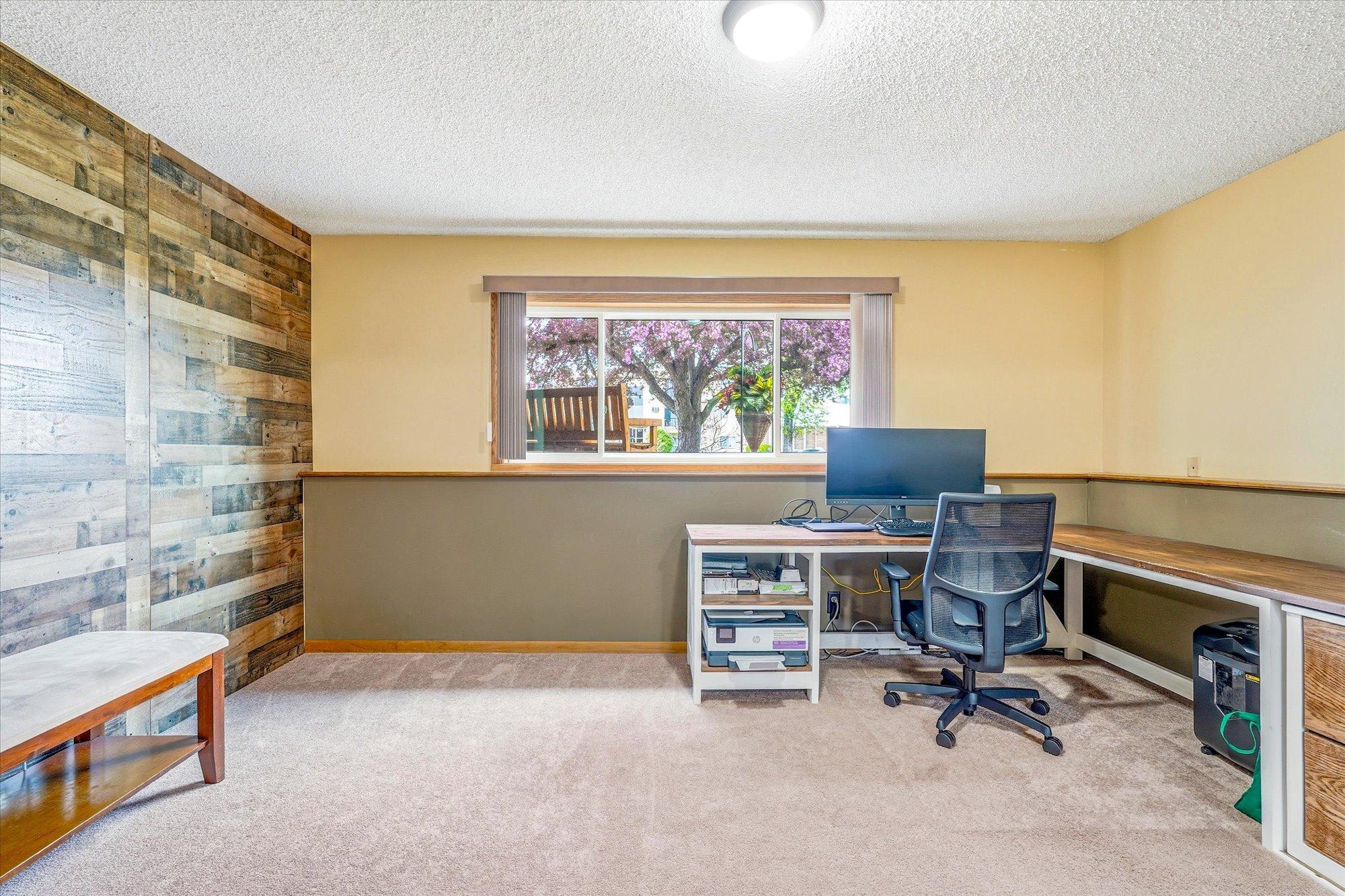 Lower-level flex space with custom wood accent walls makes a great office, workout, or hobby area.