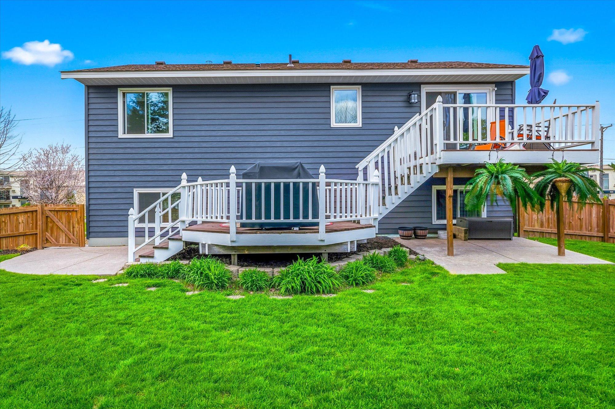 Expansive deck overlooks the lush backyard and provides multiple spaces for grilling, relaxing, and outdoor gatherings.