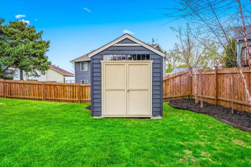 Storage shed provides excellent space for lawn equipment, tools, and additional outdoor storage.