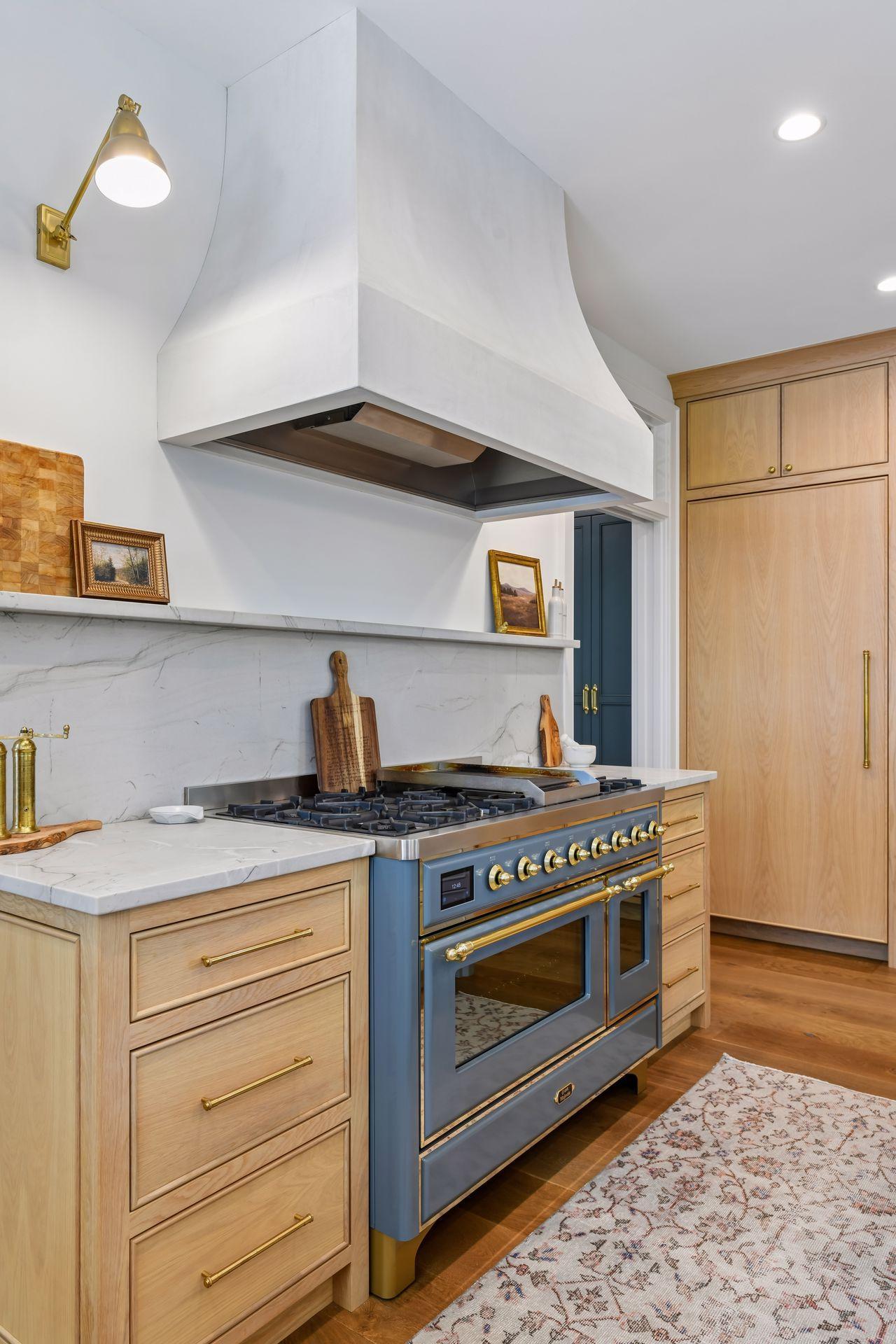 48" Ilve Dual Fuel Range with 8 burners and a griddle. Custom Venetian plaster range hood. Marble backsplash.