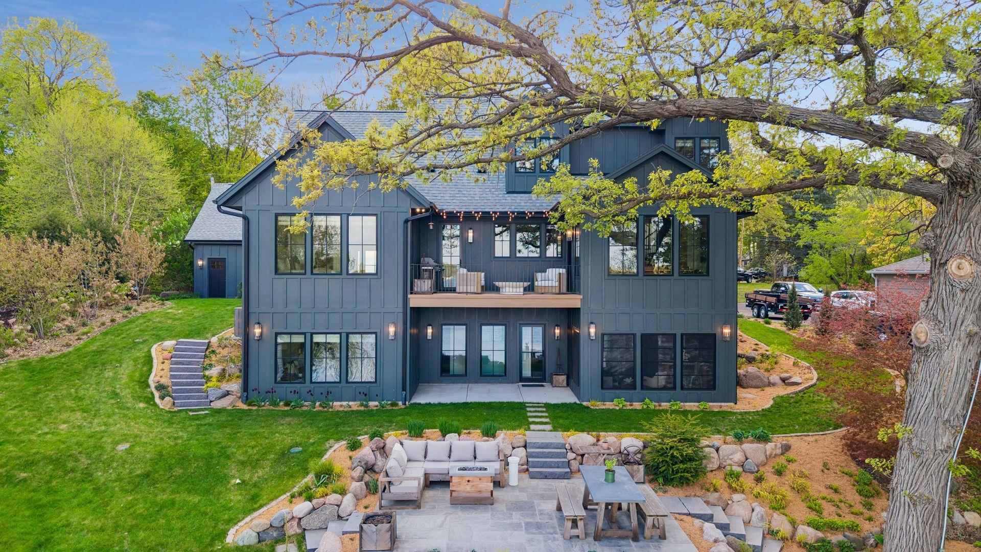 The luxury home is beautiful inside and out. View of the back of the house, offering multiple spots to relax and enjoy the lake and the call of the loons. Practically every room in the house offers lake views.