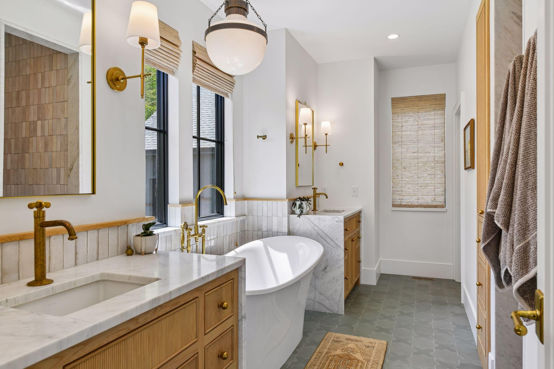 Primary bath with unlaquered brass faucets from an artisan out of Morocco. Star and Cross cement tile on heated floor. Victoria and Albert Volcanic Limestone soaker tub. Separate water closet.