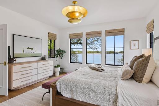 Another view of the primary bedroom. Large windows on the 3 exterior walls create a feeling of being in nature all the time. Furniture is available for sale but please exclude the painting over the dresser.
