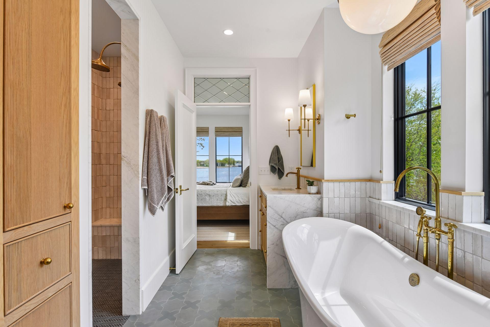 Windows from all sides offering natural light. Walk-in shower with dual shower heads and handmade tile. Linen closet. Reeding on the separate vanities and cabinets. Marble waterfall countertops.