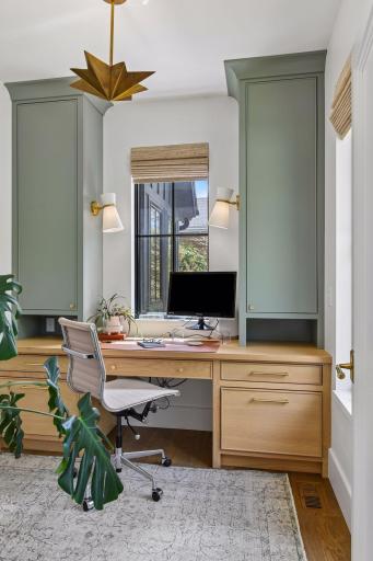 Main floor office is tucked away from the center of the house, offering privacy. Two windows fill the room with light. This room is so cheery, work will be fun! Custom cabinets and light fixtures.