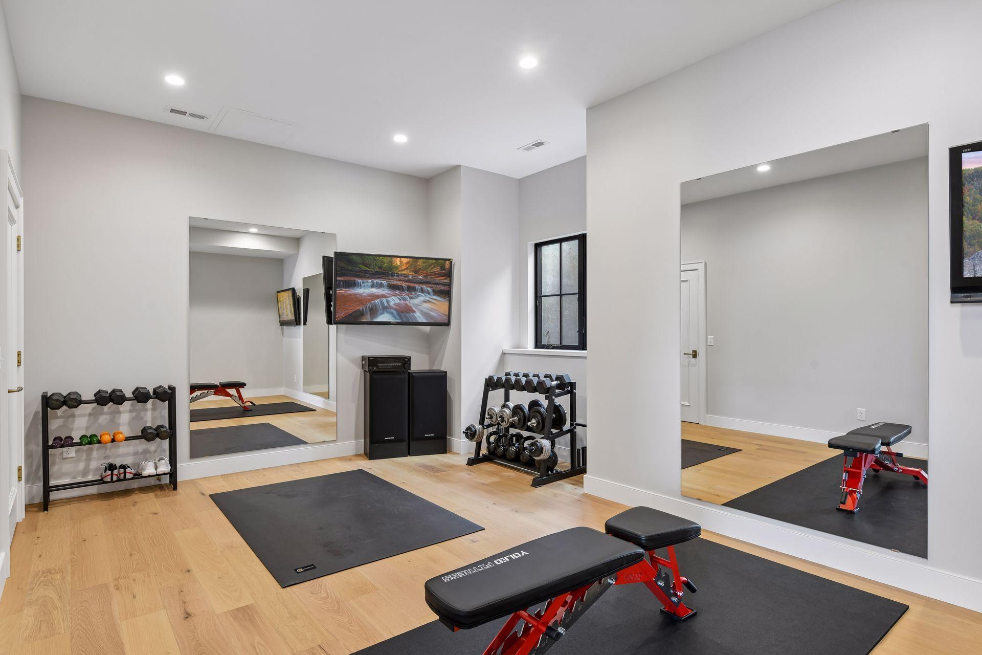 Lower level gym with space for 2 to workout together, includes 2 TVs. The floor has a commercial grade shock absorption system underneath. This room has an egress window and a closet in case you need it to be your 5th bedroom.