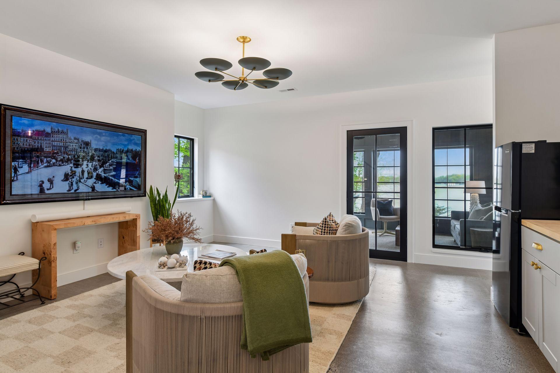 Lower-level entertainment room. Polished concrete floor. Designs available to complete the wet bar at the back of the room and to add a media console surrounding the TV.