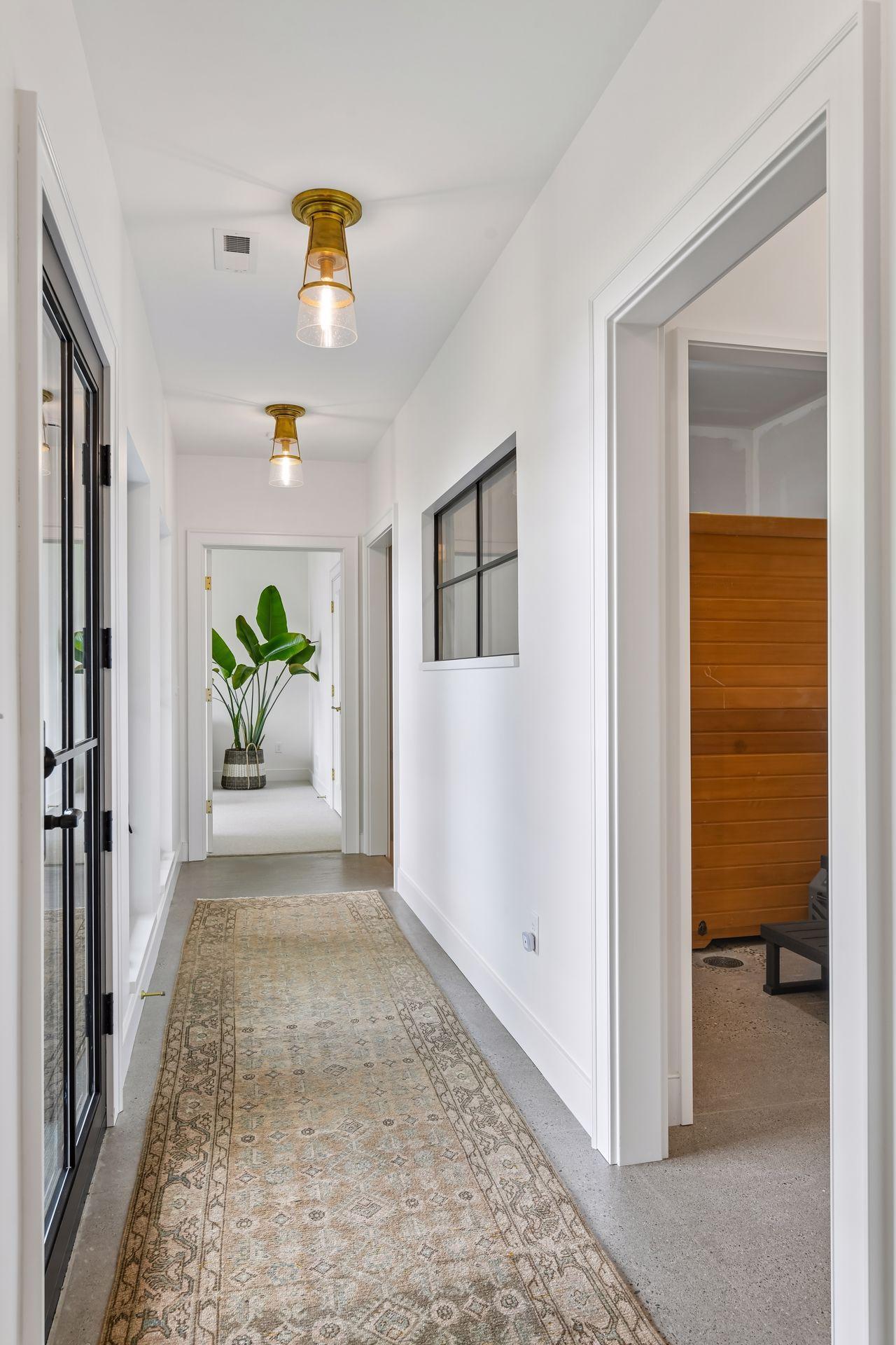 Hall leads to sauna room, bathroom, workout room and 4th bedroom. Walkout to covered patio here. The windows on the right are in the roughed-in sauna room. Design plans and selections are available to complete the sauna. Existing sauna can stay.