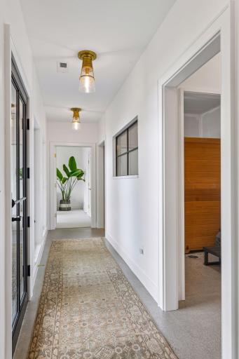 Hall leads to sauna room, bathroom, workout room and 4th bedroom. Walkout to covered patio here. The windows on the right are in the roughed-in sauna room. Design plans and selections are available to complete the sauna. Existing sauna can stay.