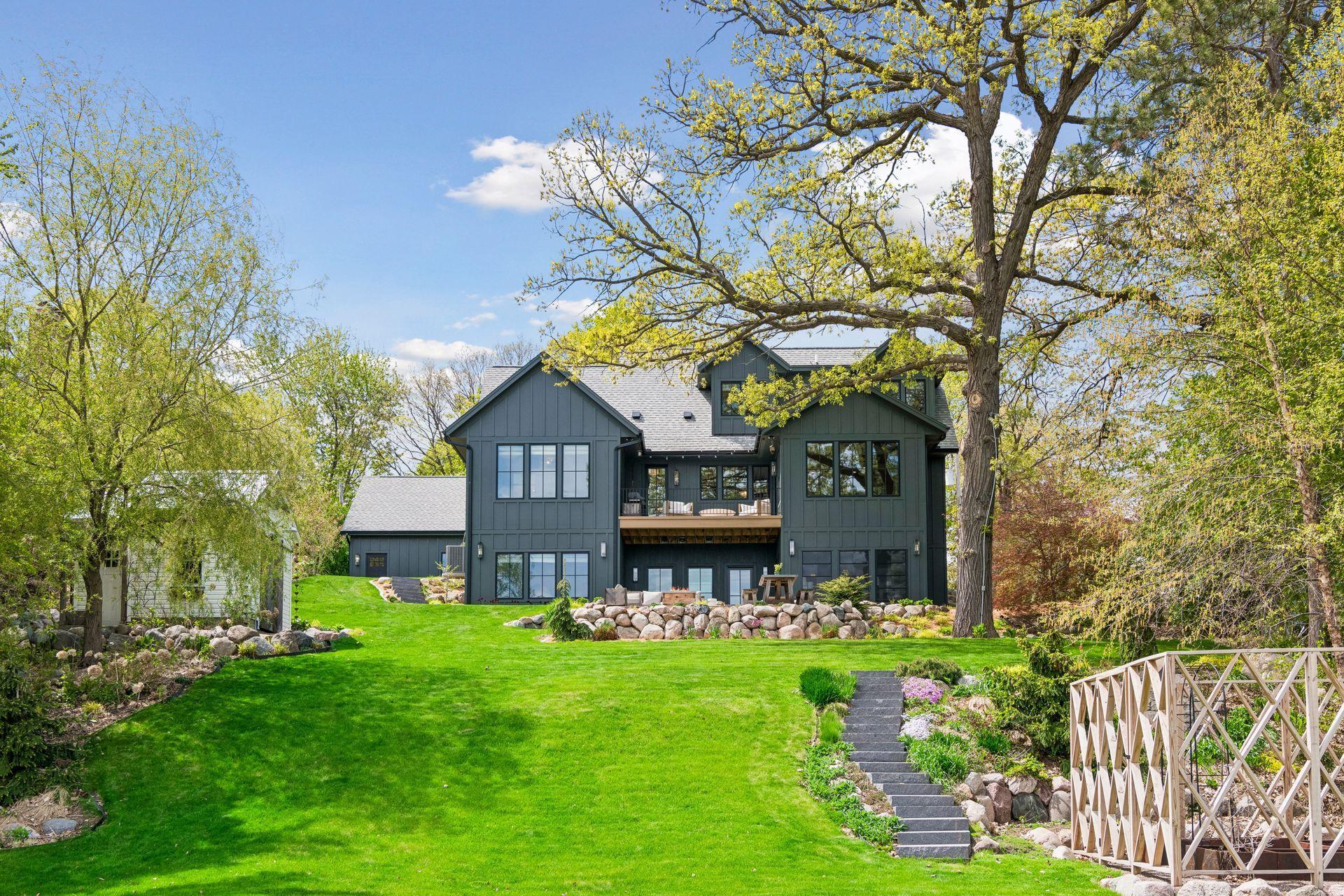 Impressive back yard with boulder retaining wall at the patio and granite staircases to the lake.