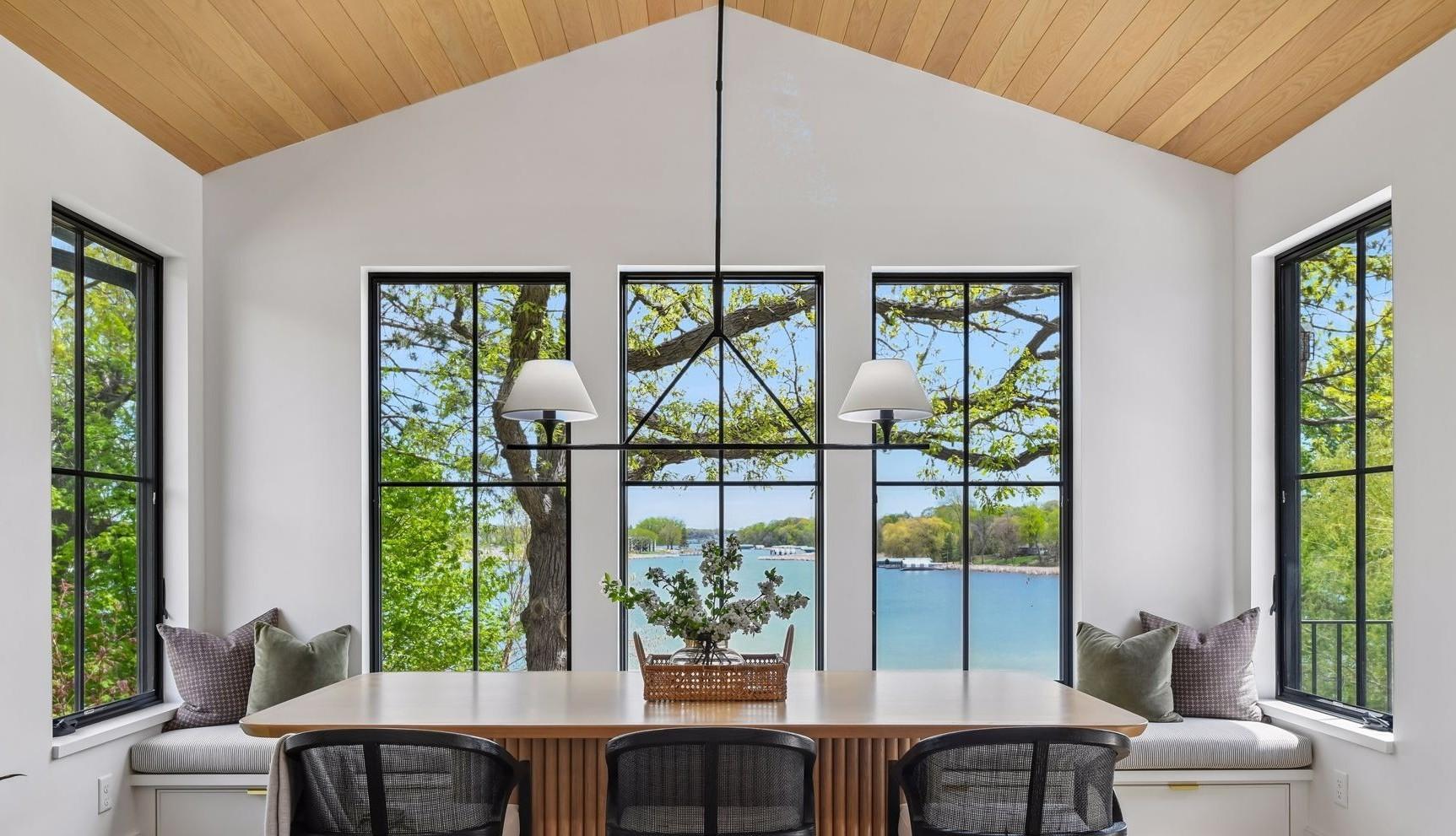 Award-winning dining room is breathtaking. 2nd place 2024 Midwest Design Award for Contemporary Dining. White oak tongue and groove planks on the ceiling. Large windows on all 3 sides of the room. Door conveniently opens to the deck.