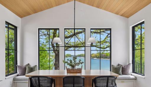 Award-winning dining room is breathtaking. 2nd place 2024 Midwest Design Award for Contemporary Dining. White oak tongue and groove planks on the ceiling. Large windows on all 3 sides of the room. Door conveniently opens to the deck.