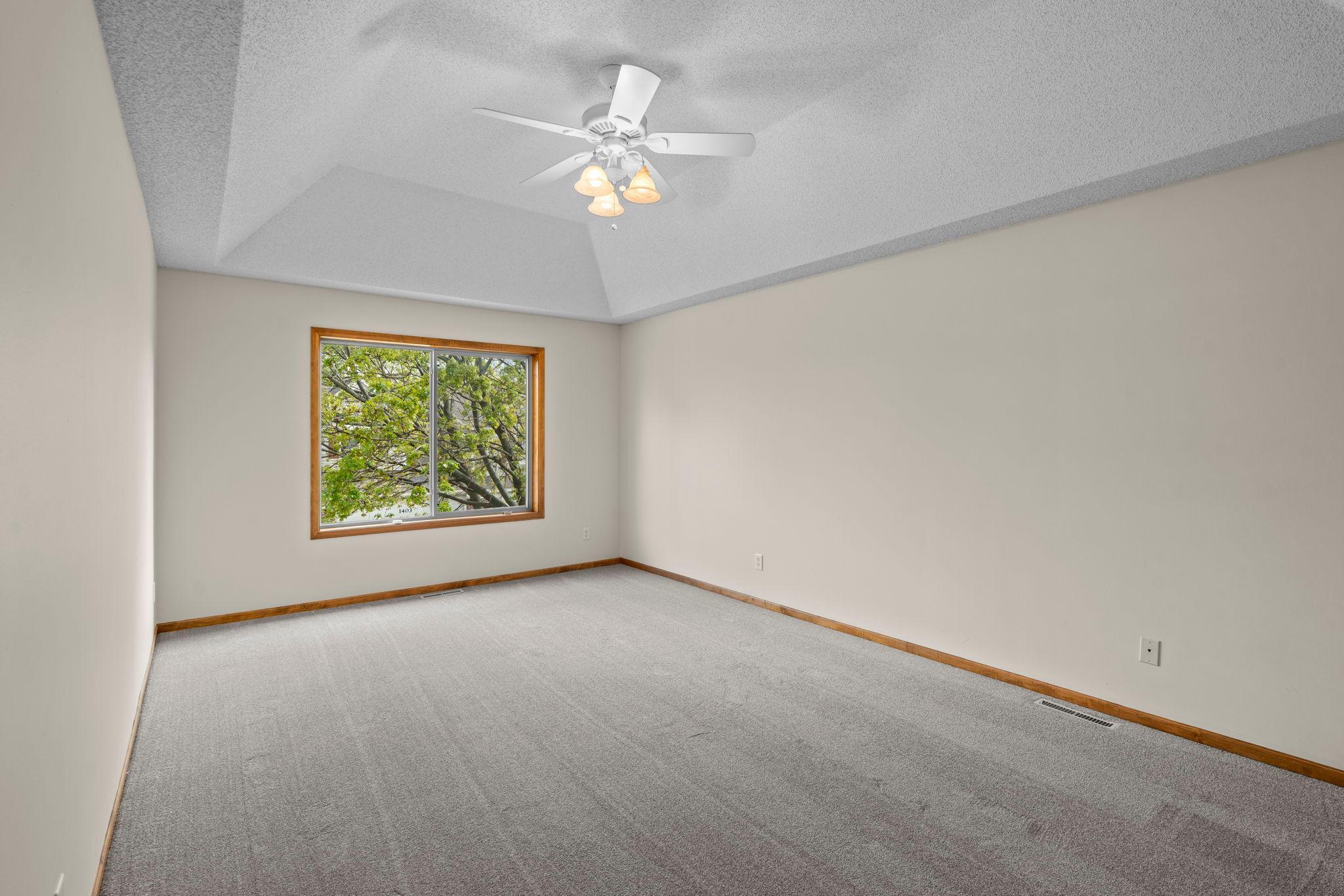 Private, main level primary with beautiful tray ceiling and large window.