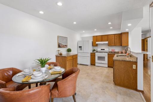 The kitchen features an eat-in breakfast bar counter seating and a movable island with matching granite countertop.