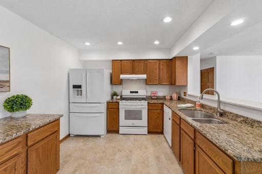 The kitchen includes a French door refrigerator with double pull-out drawers, gas range stove, dishwasher, and double-sink.