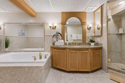 Lower level full bath with matching tile floors, walls, bath, and shower.