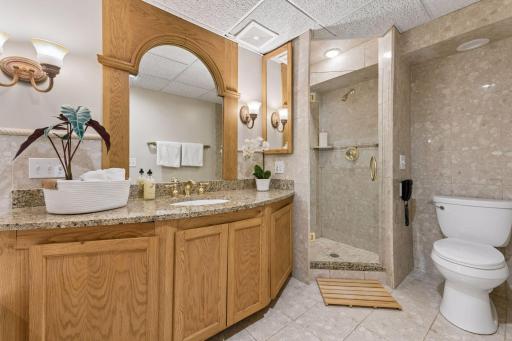Large vanity and separate step-in shower with floor to ceiling tile.
