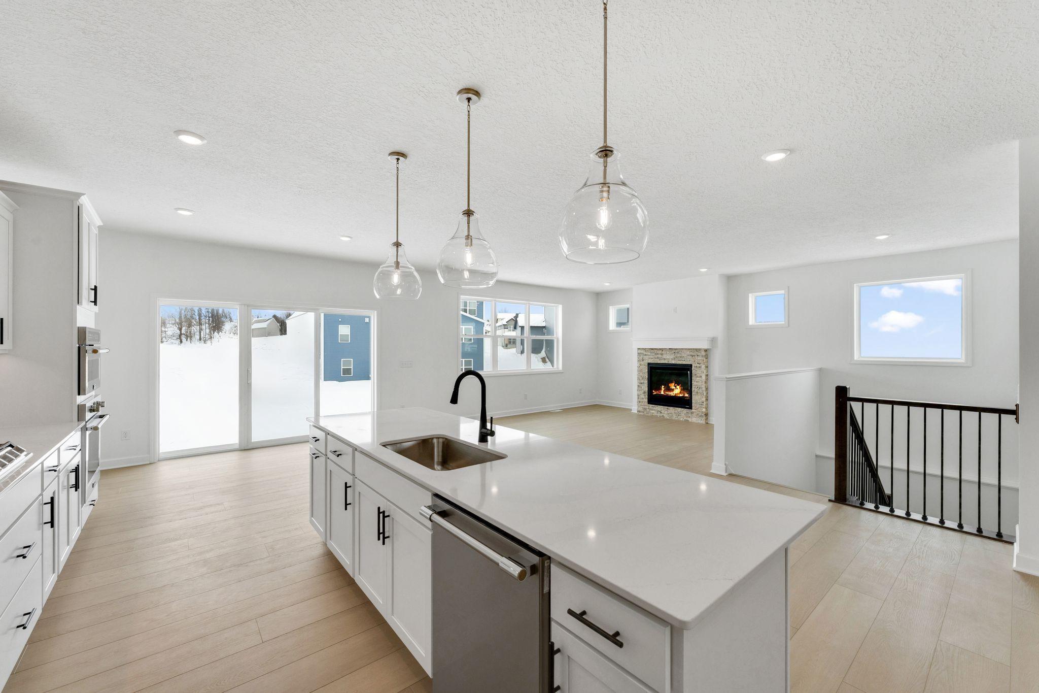 (Photo of a similar home, actual finishes may vary) The modern kitchen comes equipped with popular features like smudge-proof appliances and designer-selected cabinetry, along with a spacious center island for bar-style meals and easy entertaining.
