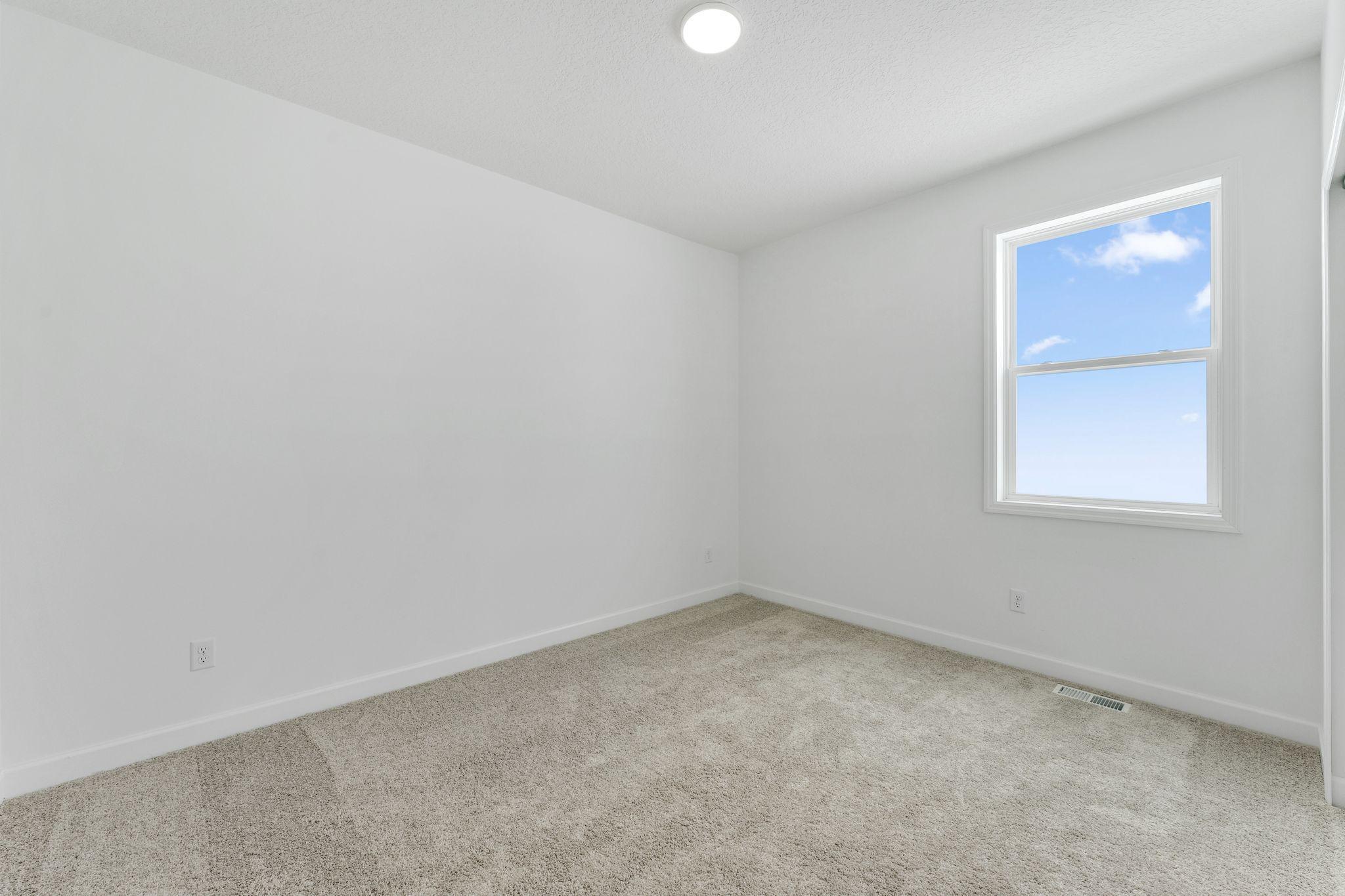 (Photo of a similar home, actual finishes may vary) Either of the two secondary bedrooms can be transformed to suit the homeowner’s evolving needs, shown here as a custom office for work projects.