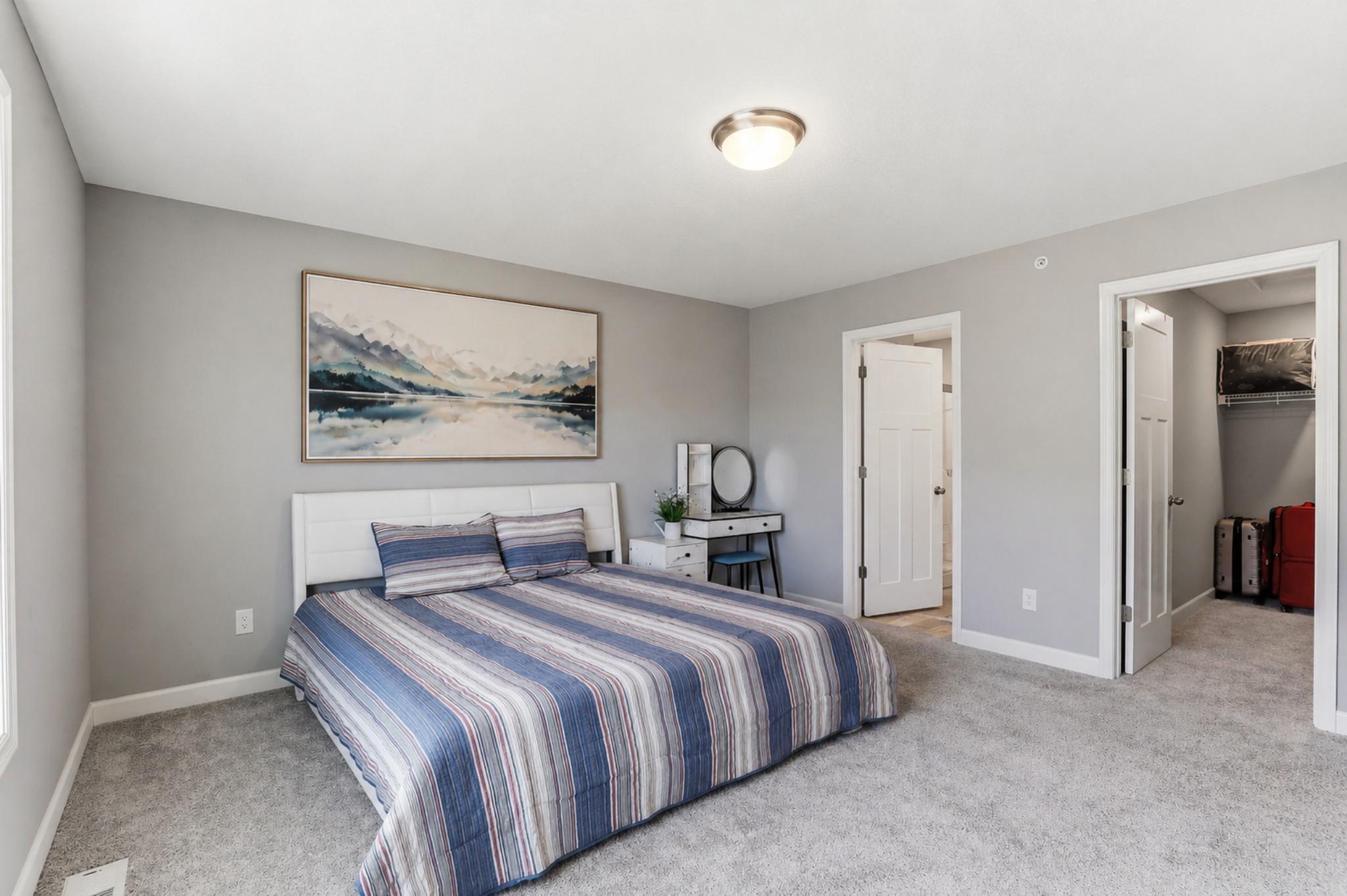 Master bedroom features a generous walk-in closet and a private ensuite bath. (contains digital wall art)