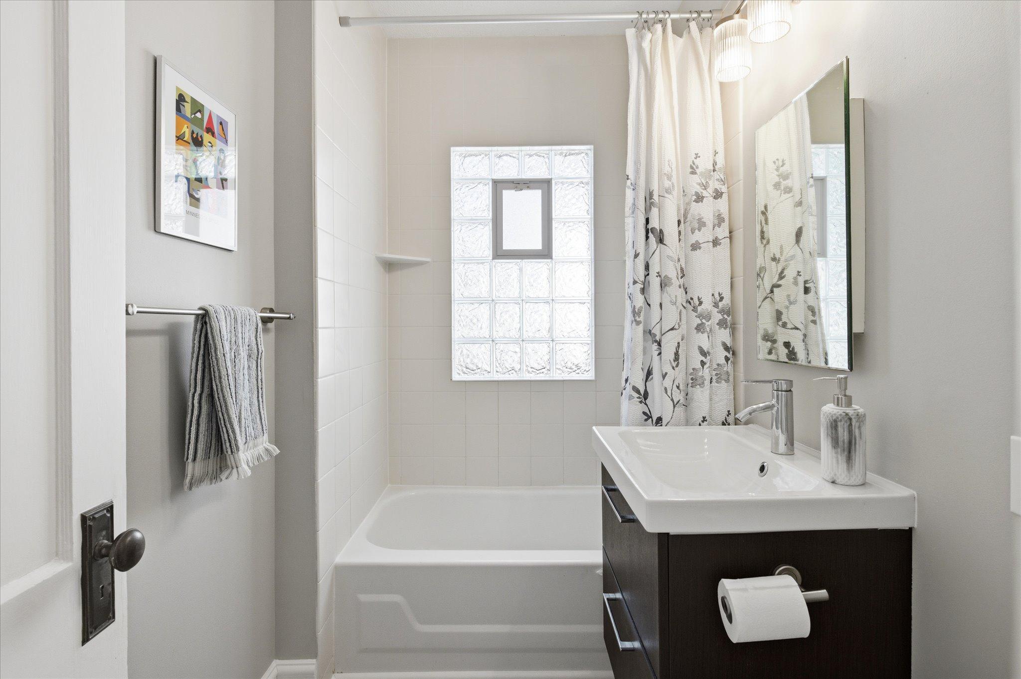 The main-floor full bathroom has been thoughtfully updated with a clean and timeless design.