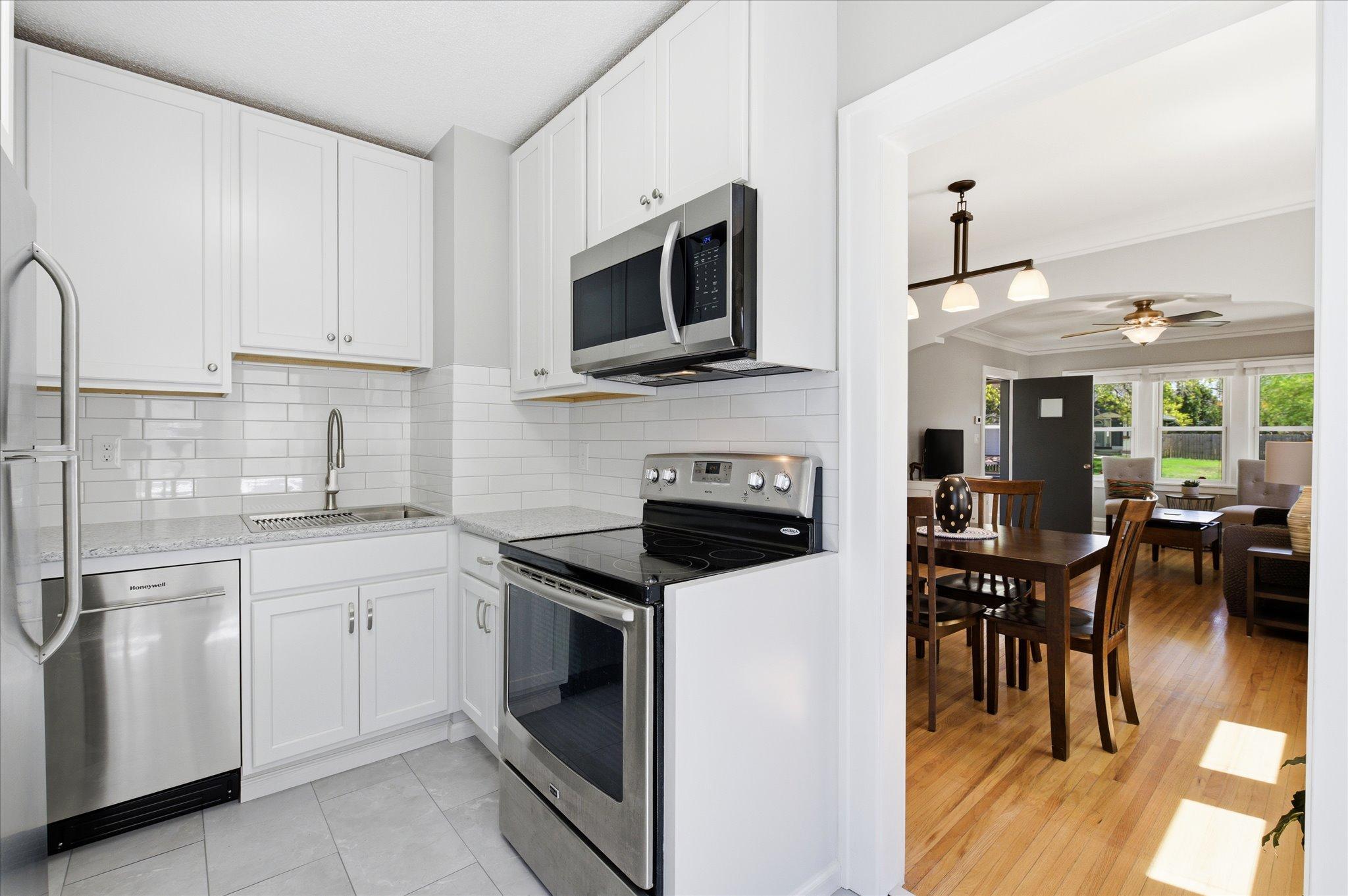 Abundant cabinetry, stainless steel appliances, and easy access to both the kitchen and dining area make this space highly functional.