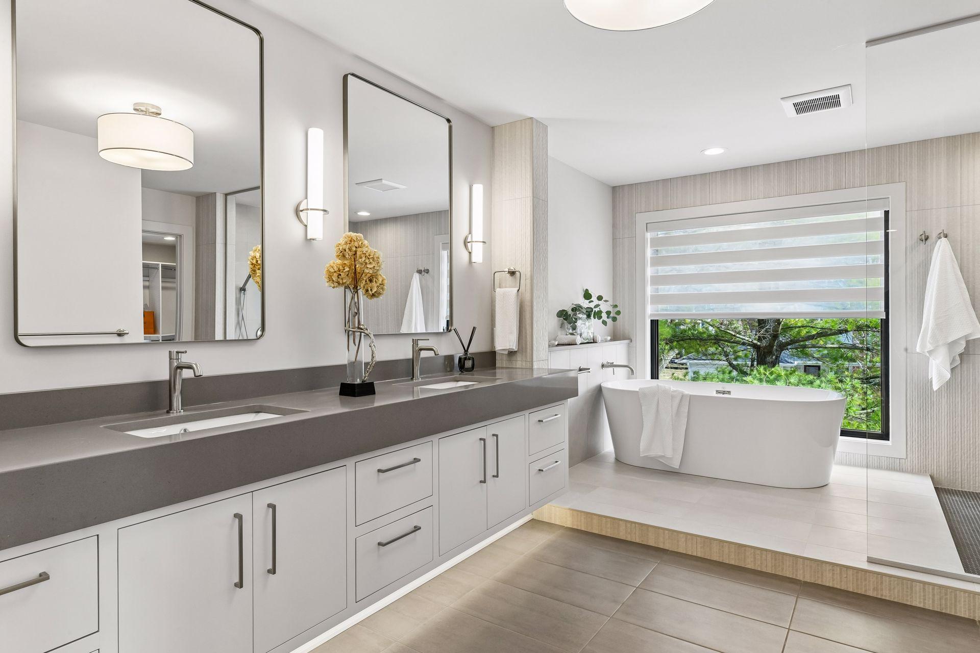 Master bath with heated floors, double vanity, custom built-ins & soaking tub with smart shade.