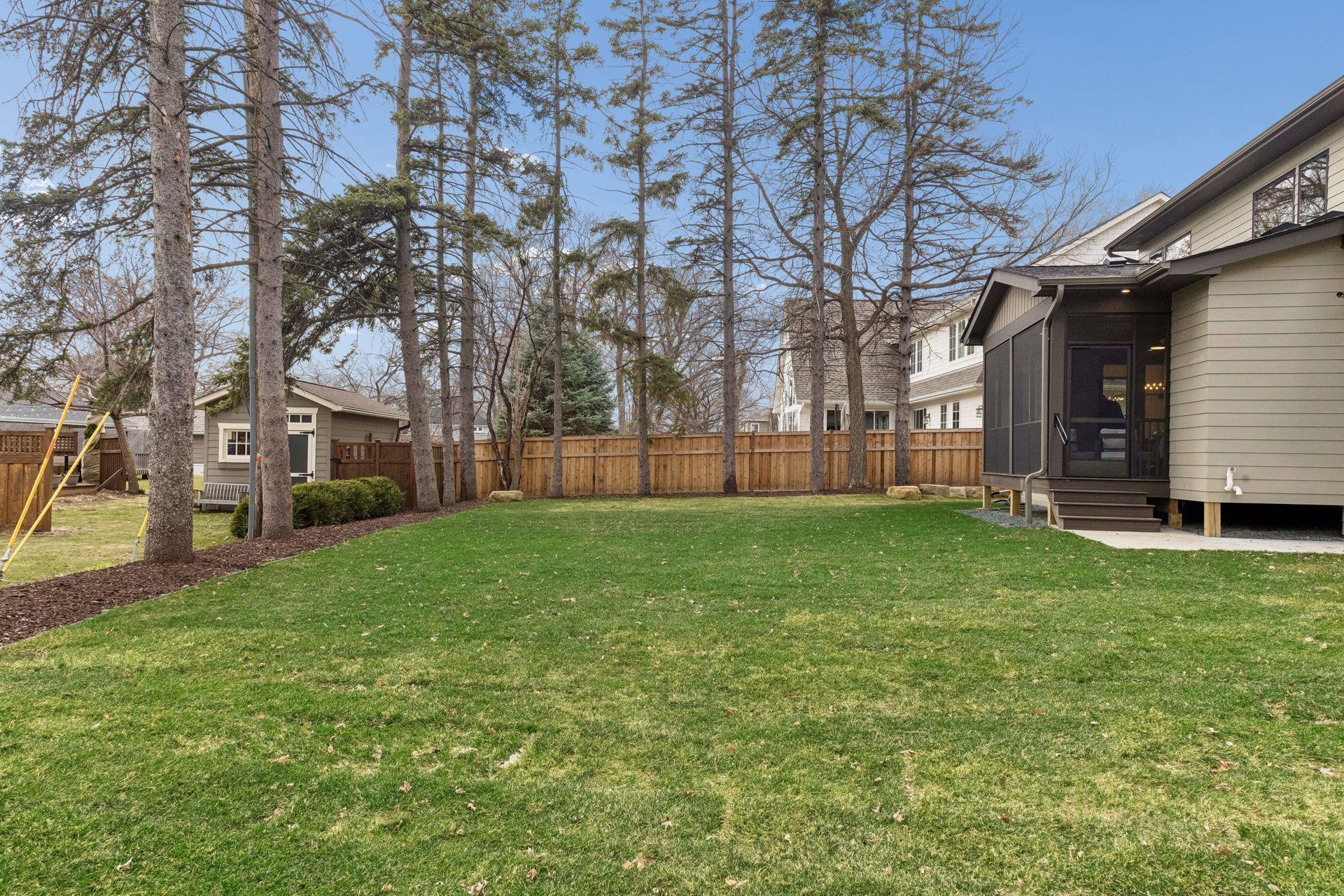 Screened porch steps out to spacious level yard.