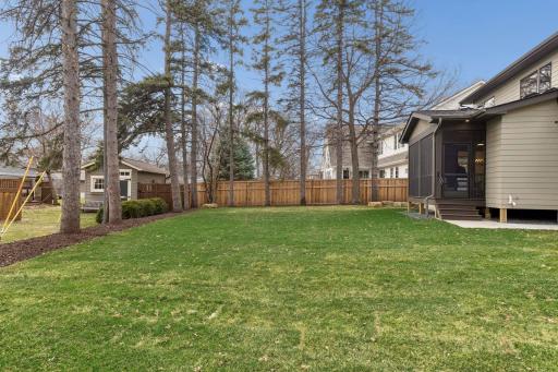 Screened porch steps out to spacious level yard.