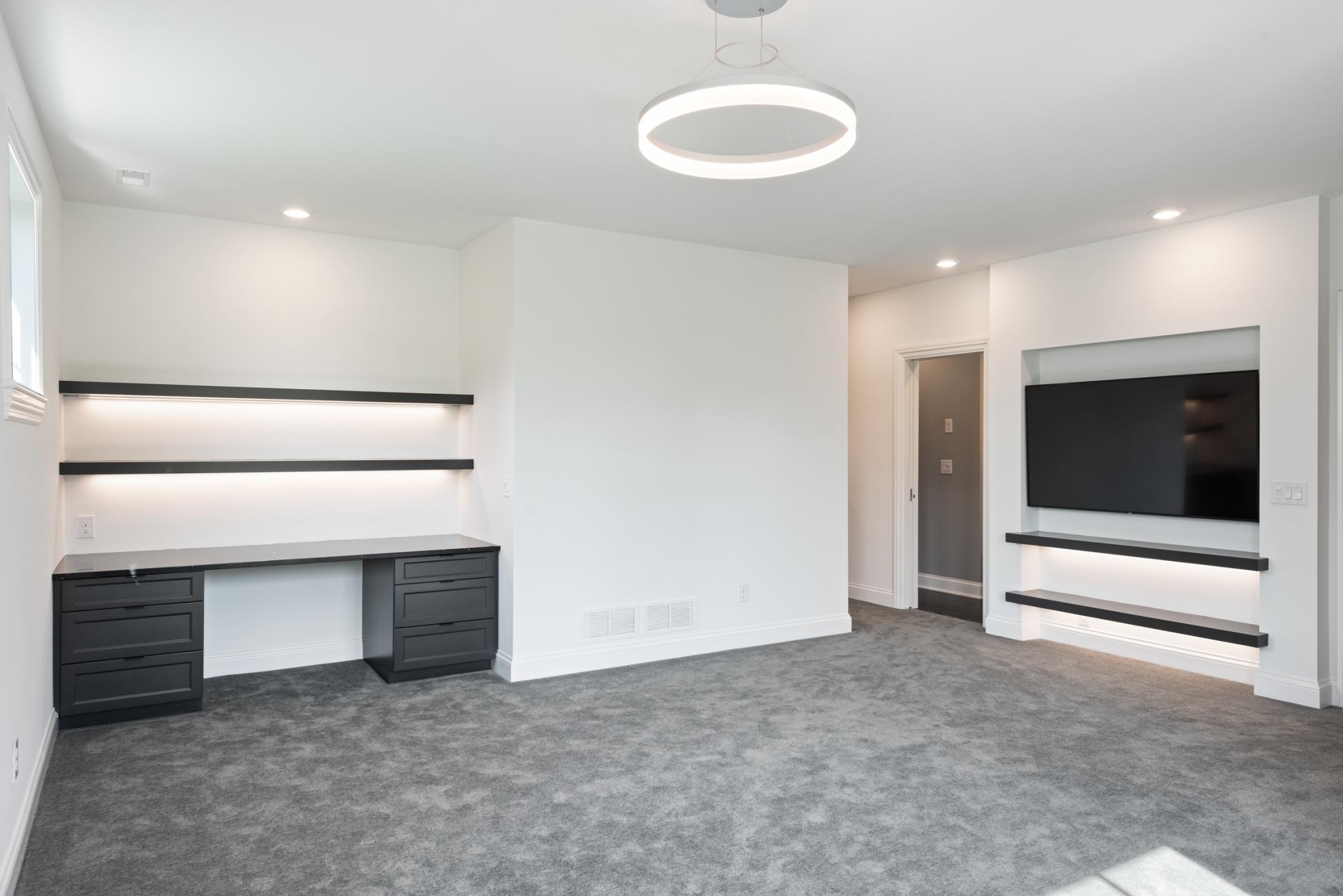 Second bedroom on the lower level with a desk, walk-in closet, and en-suite bathroom