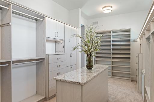 Spacious primary walk-in closet with custom built-ins, center island, and thoughtfully designed storage for effortless organization.
