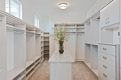 Spacious primary walk-in closet with custom built-ins, center island, and thoughtfully designed storage for effortless organization.