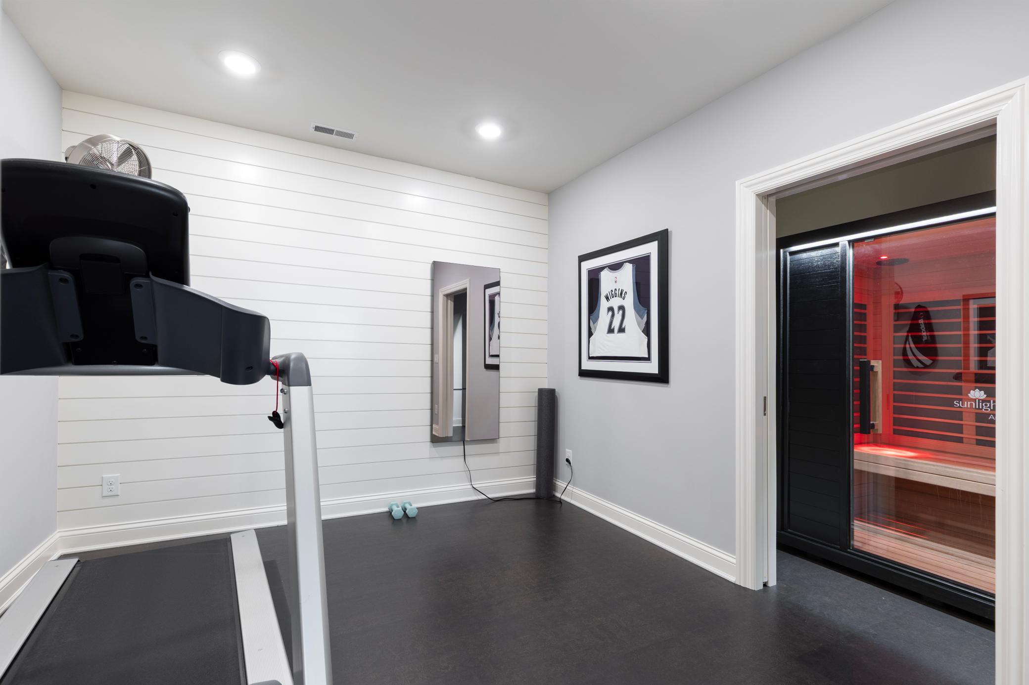 Lower level exercise room with custom red-light therapy sauna for ultimate wellness