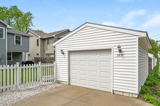 Extra wide garage offers room for storage and hobbies plus additional parking on the cement pad