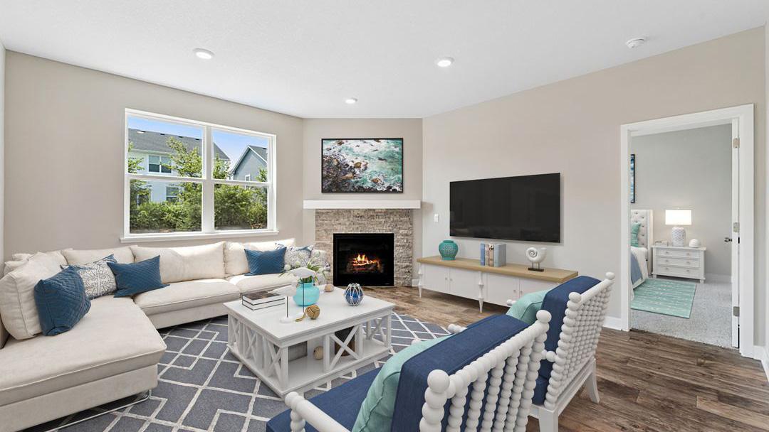 Separate living room space with the corner gas fireplace makes for a cozy feeling home. Model photo. Options and colors will vary in our available inventory homes.