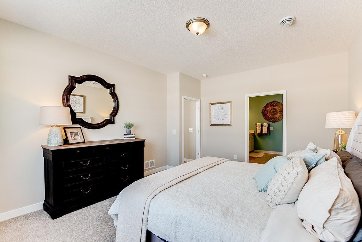 Another view of the primary bedroom. Nine feet ceilings on the main level of the home make the space feel even bigger! Model photo. Options and colors will vary in our available inventory homes.
