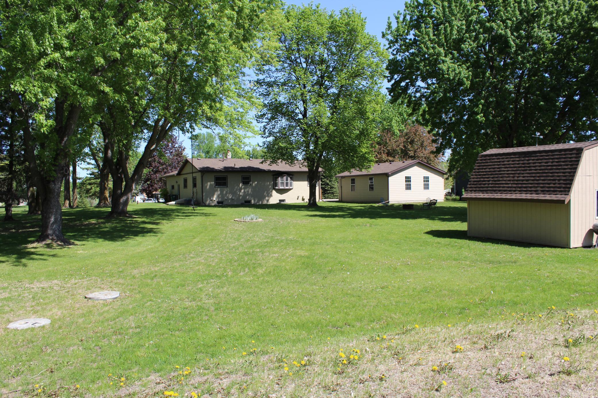 View of the back of the home, the detached garage, and the garden/storage shed