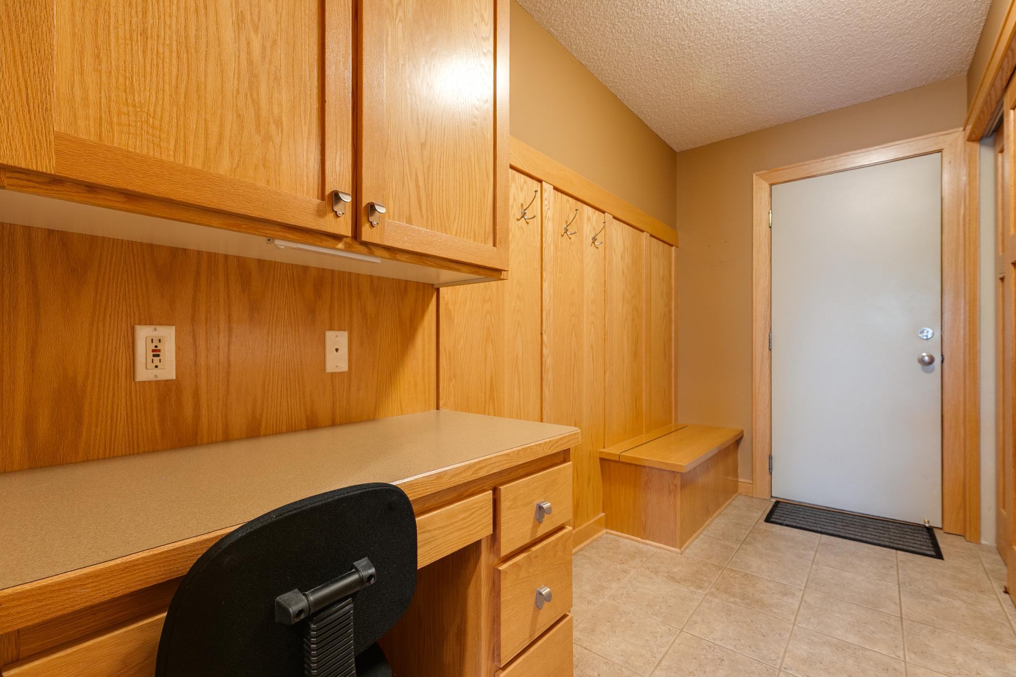 From the garage, you will enter the home through the laundry room, which is complete with an entry bench, a working desk and a laundry sink.