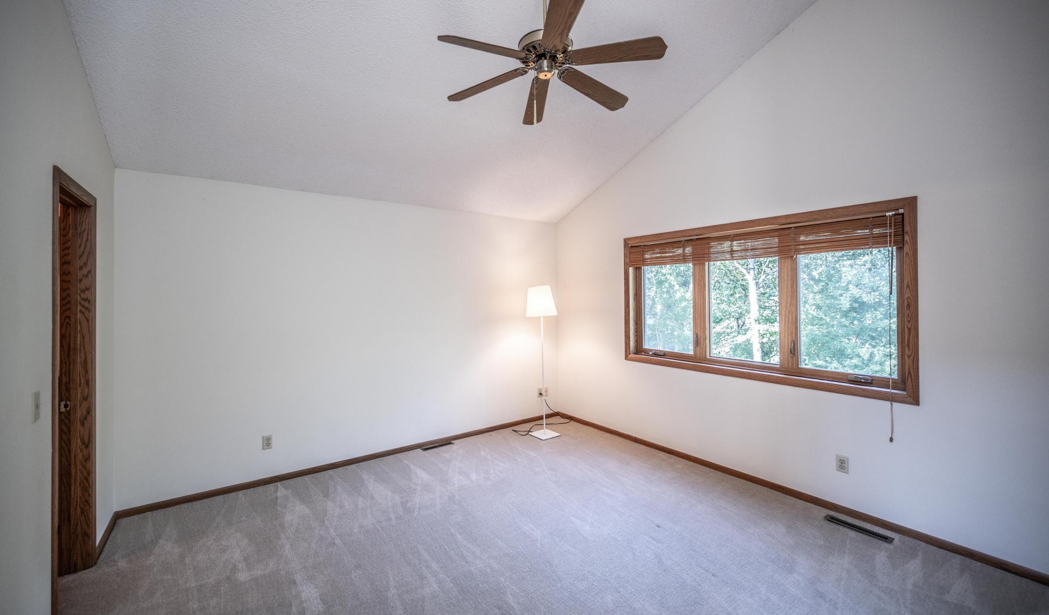 Owner's bedroom with large windows, ceiling fan, vaulted ceiling and newer carpet