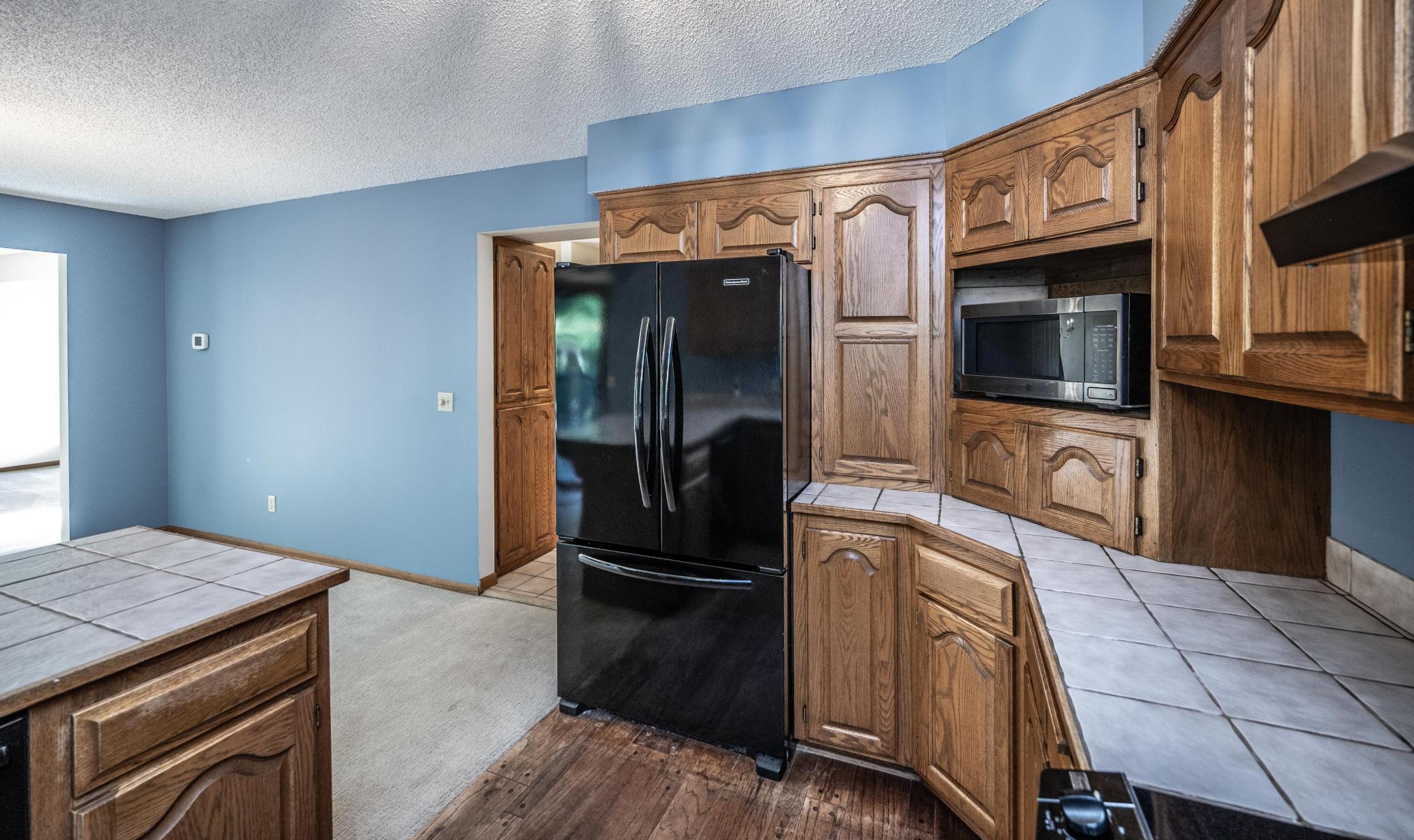 Kitchen features tile countertops and a Bosch dishwasher