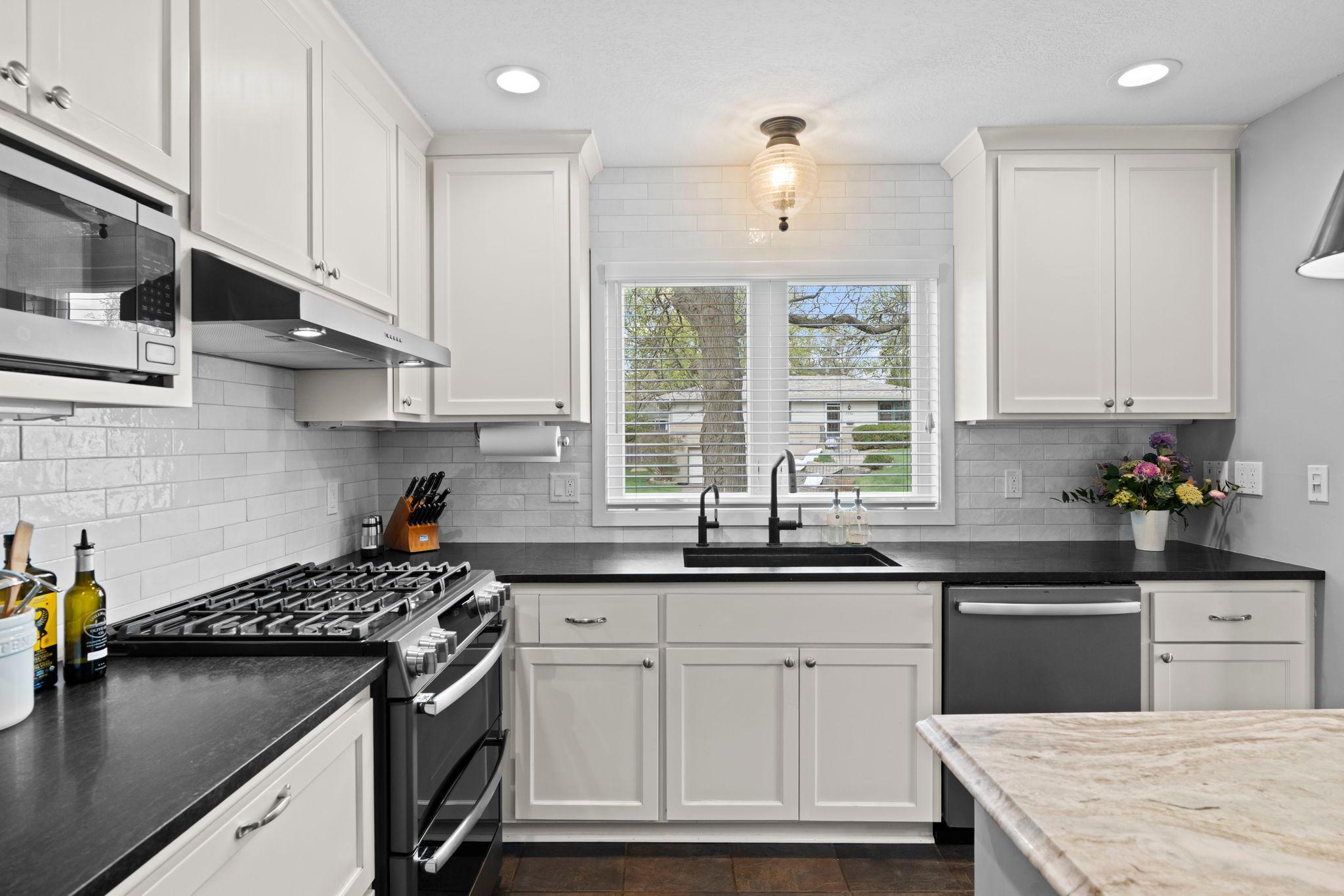 Modern, updated kitchen with white cabinetry, gas range, Granite / Quartz countertops.