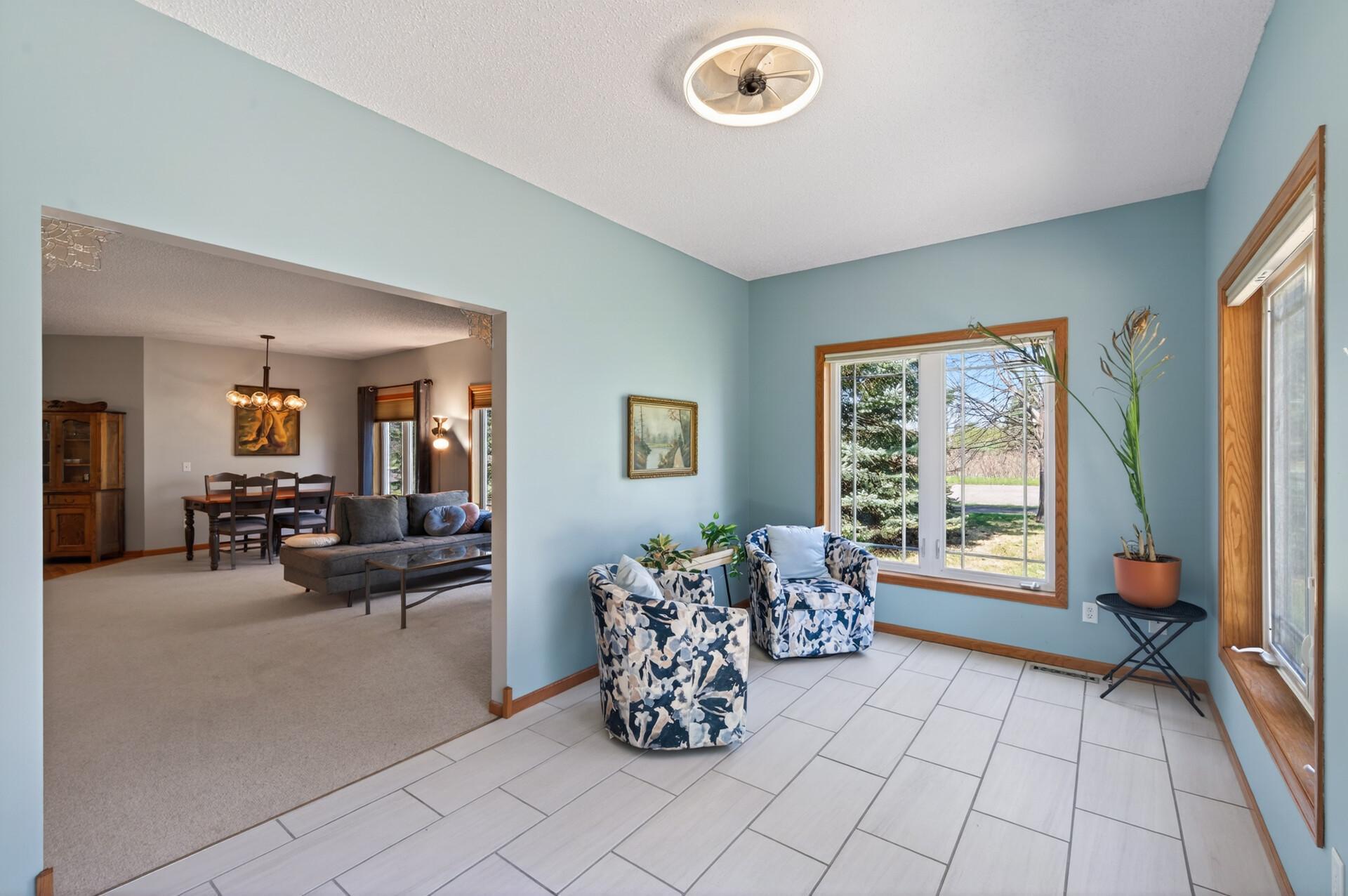 The sunroom has new porcelain tile and tons of natural light overlooking the back yard area.