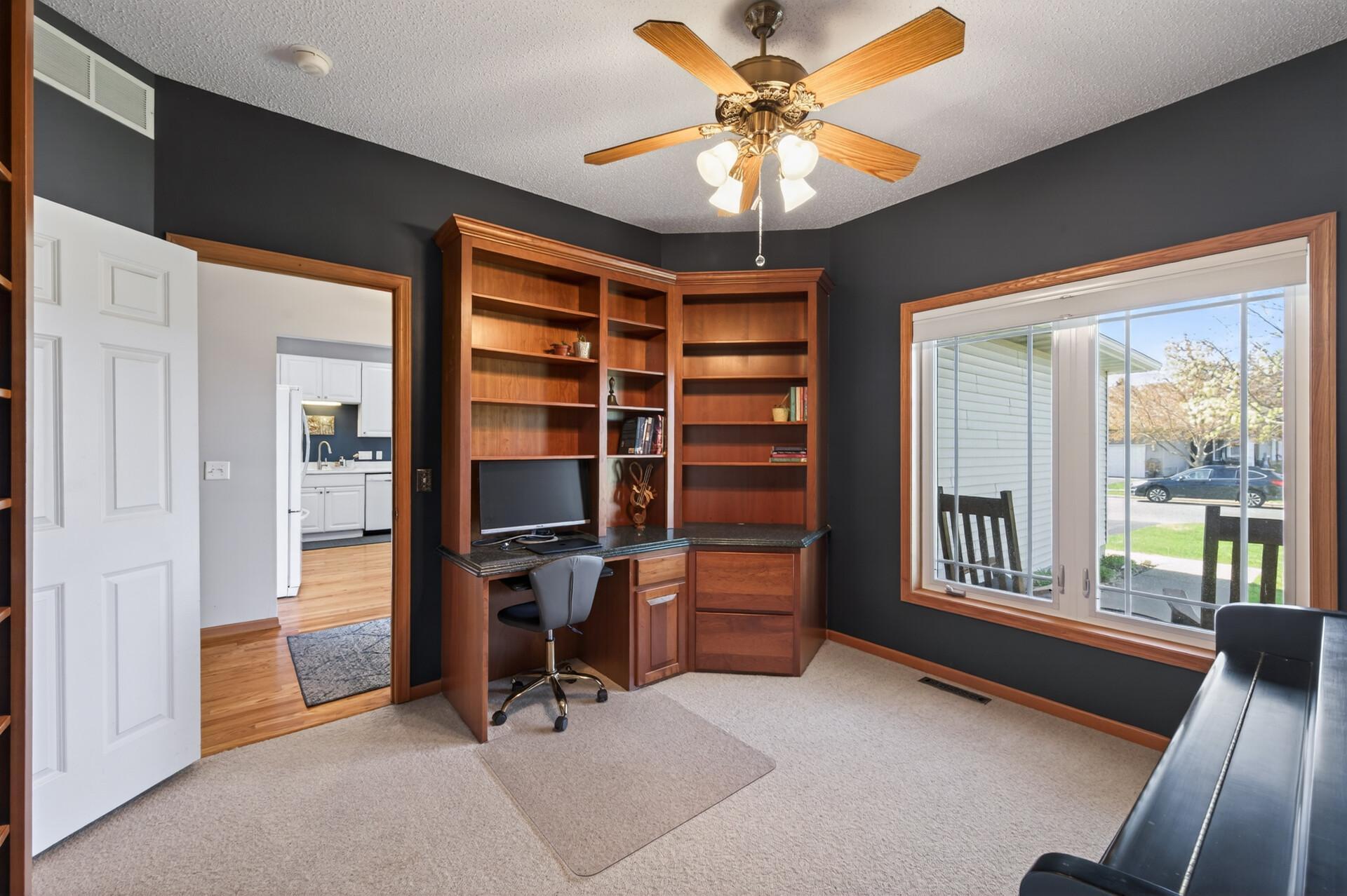 The other main-level bedroom is currently set up as an office with built-in shelving.