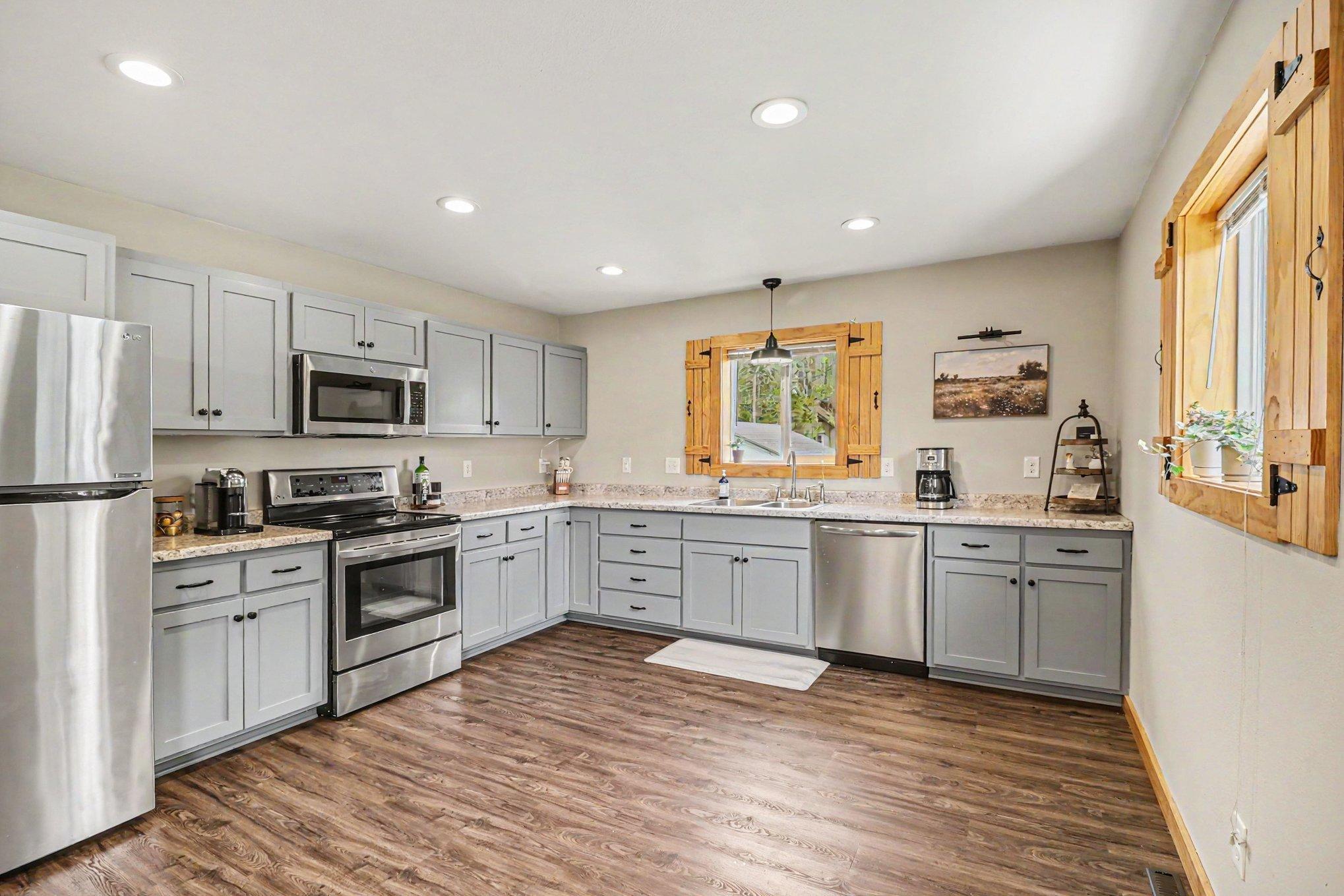 Updated kitchen with stainless appliances, gray cabinetry, LVP flooring, and pine accents — Montgomery MN