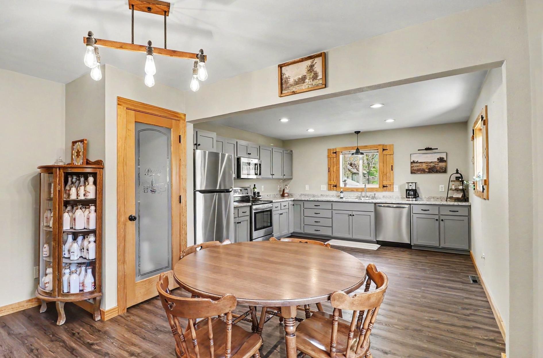 Kitchen-to-dining area with pendant lighting, LVP flooring, and open layout — 305 Oak Ave SE Montgomery